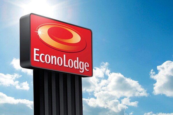 Señal de EconoLodge, con cielo despejado y nubes al fondo.