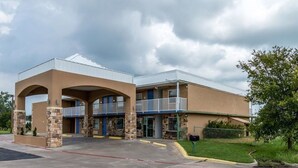 A two-story motel with a flat roof, stone pillars, and a covered entrance. - Econo Lodge Mineral Wells (Mineral Wells)