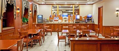 A hotel lobby with wooden furniture, a reception desk, and a large mirror.