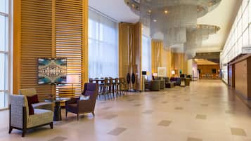 Un hall espacioso con muebles modernos, amplias ventanas y un diseño de techo original.
