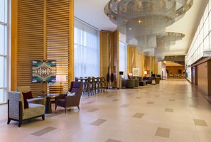 A spacious lobby with modern furniture, large windows, and a unique ceiling design. - Hilton San Diego Bayfront (San Diego)