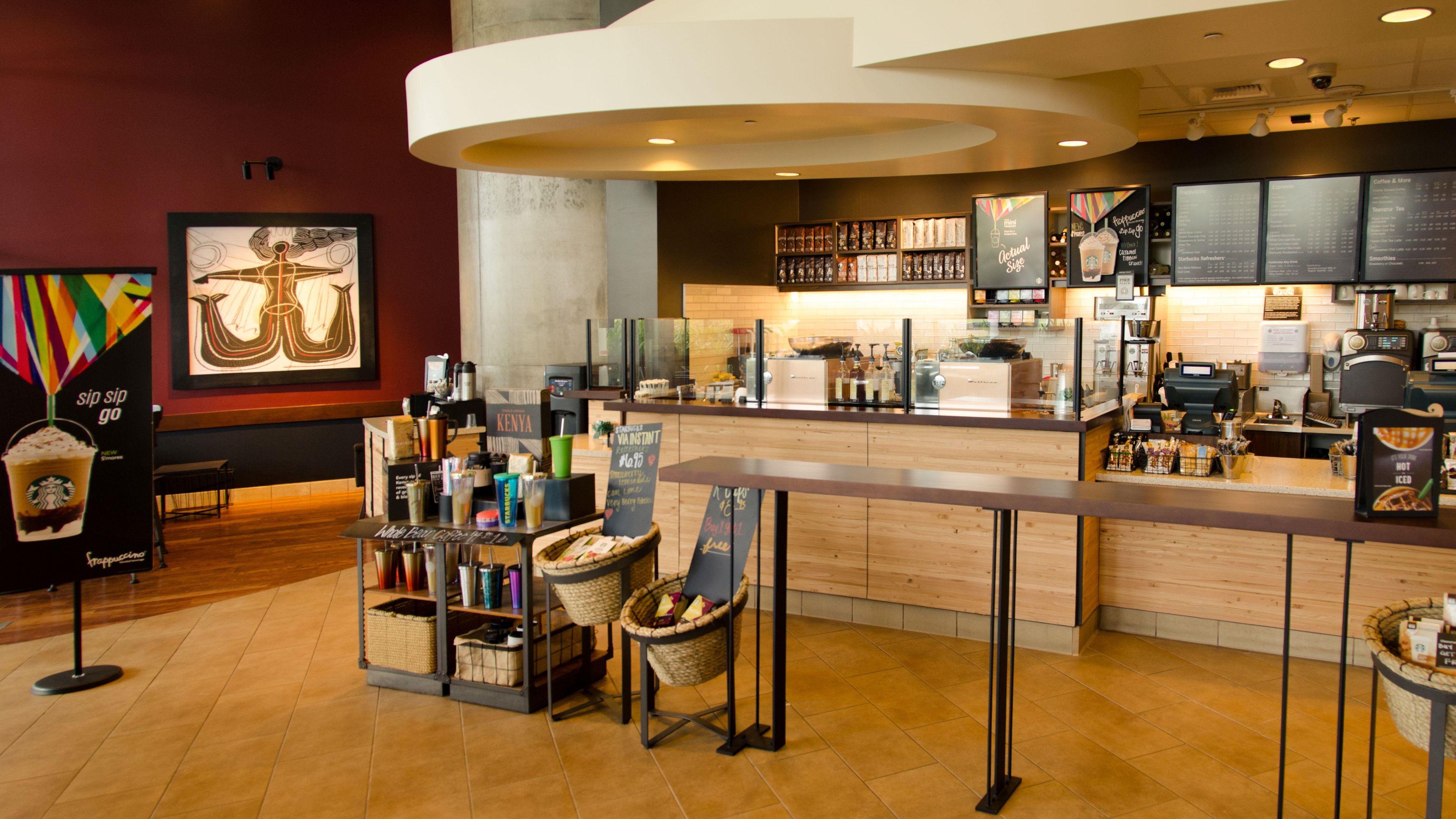 A modern coffee shop interior with a bar area, seating, and a menu display.