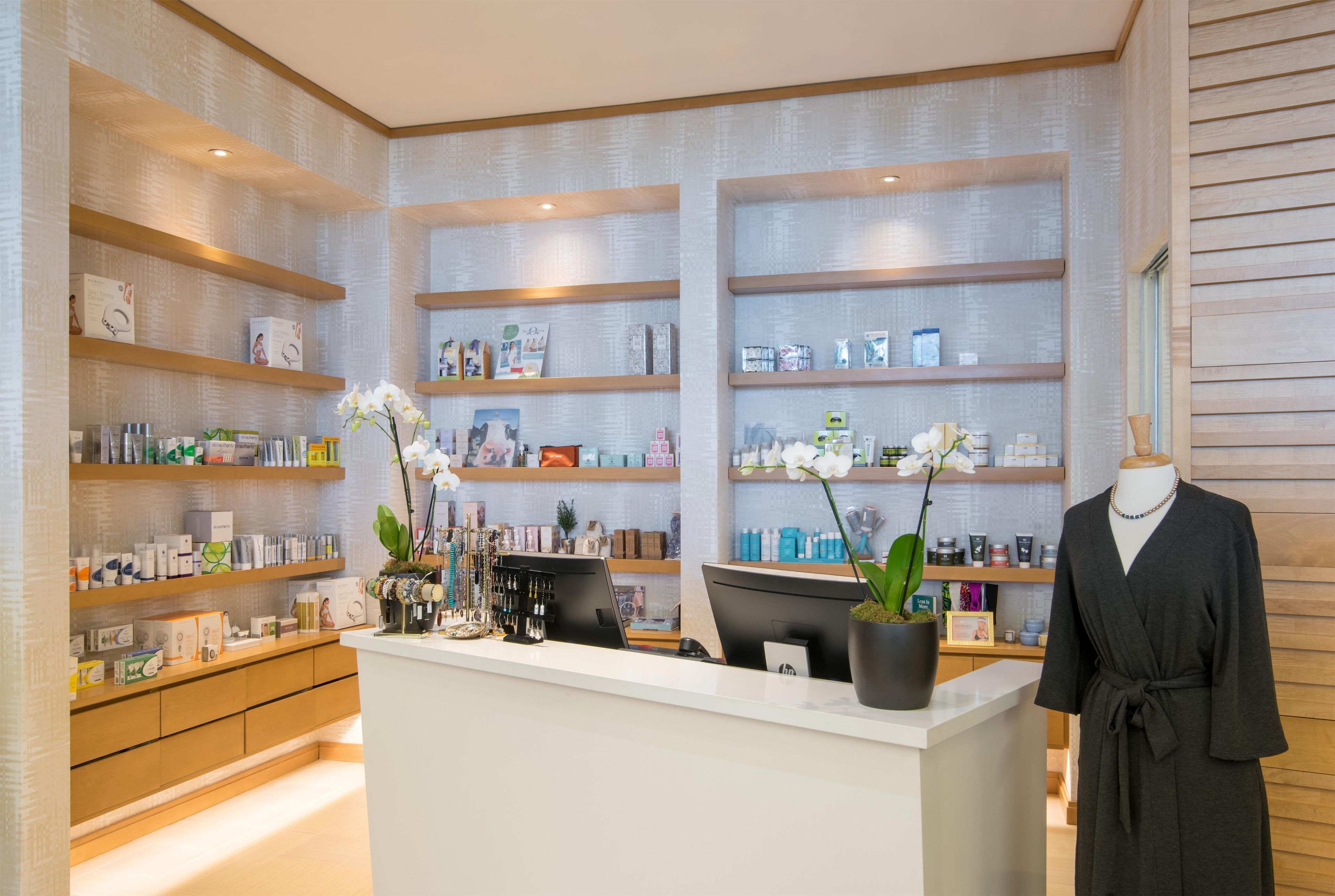 Un spa moderno con estantes de madera que exhiben diversos productos para el cuidado de la piel.