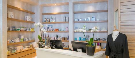 Un spa moderno con estantes de madera que exhiben diversos productos para el cuidado de la piel.