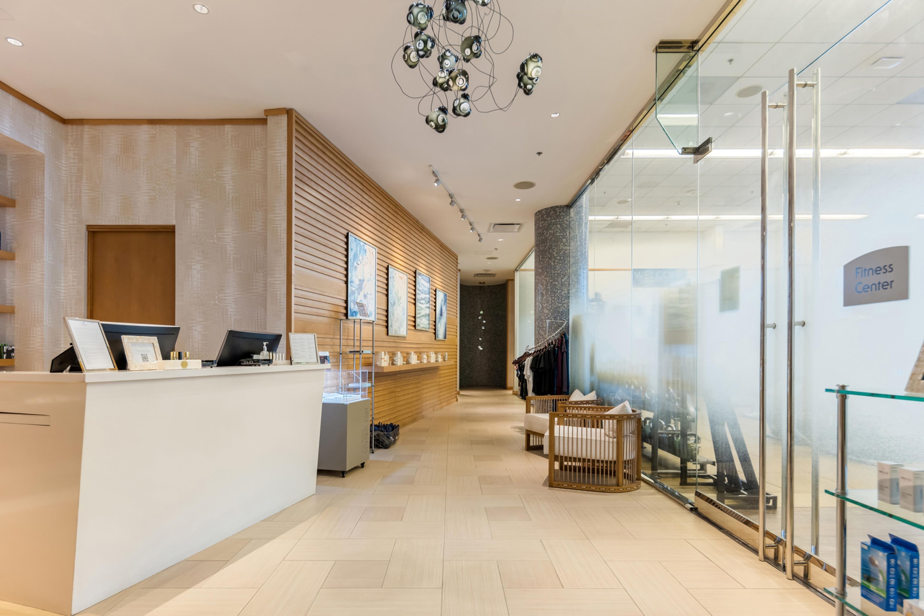 A reception area with a counter, seating, and a glass wall with a sign.