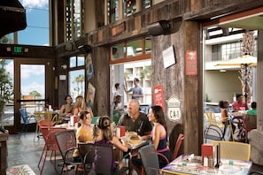 A restaurant with outdoor seating, wooden walls, and a view of the street. - Captain's Quarters Resort (Myrtle Beach)