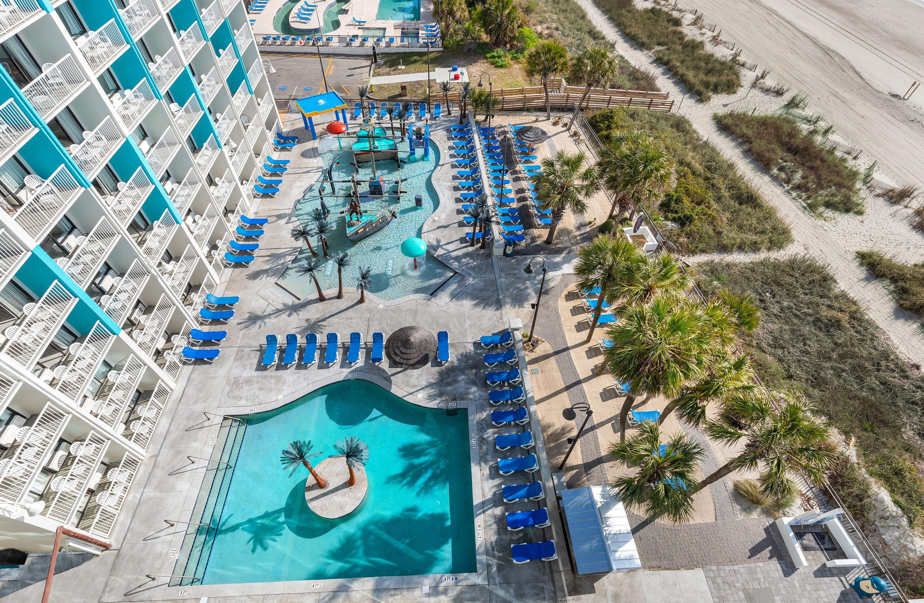 Ein Hotel mit Poolbereich, Liegestühlen und einer Wasserrutsche.