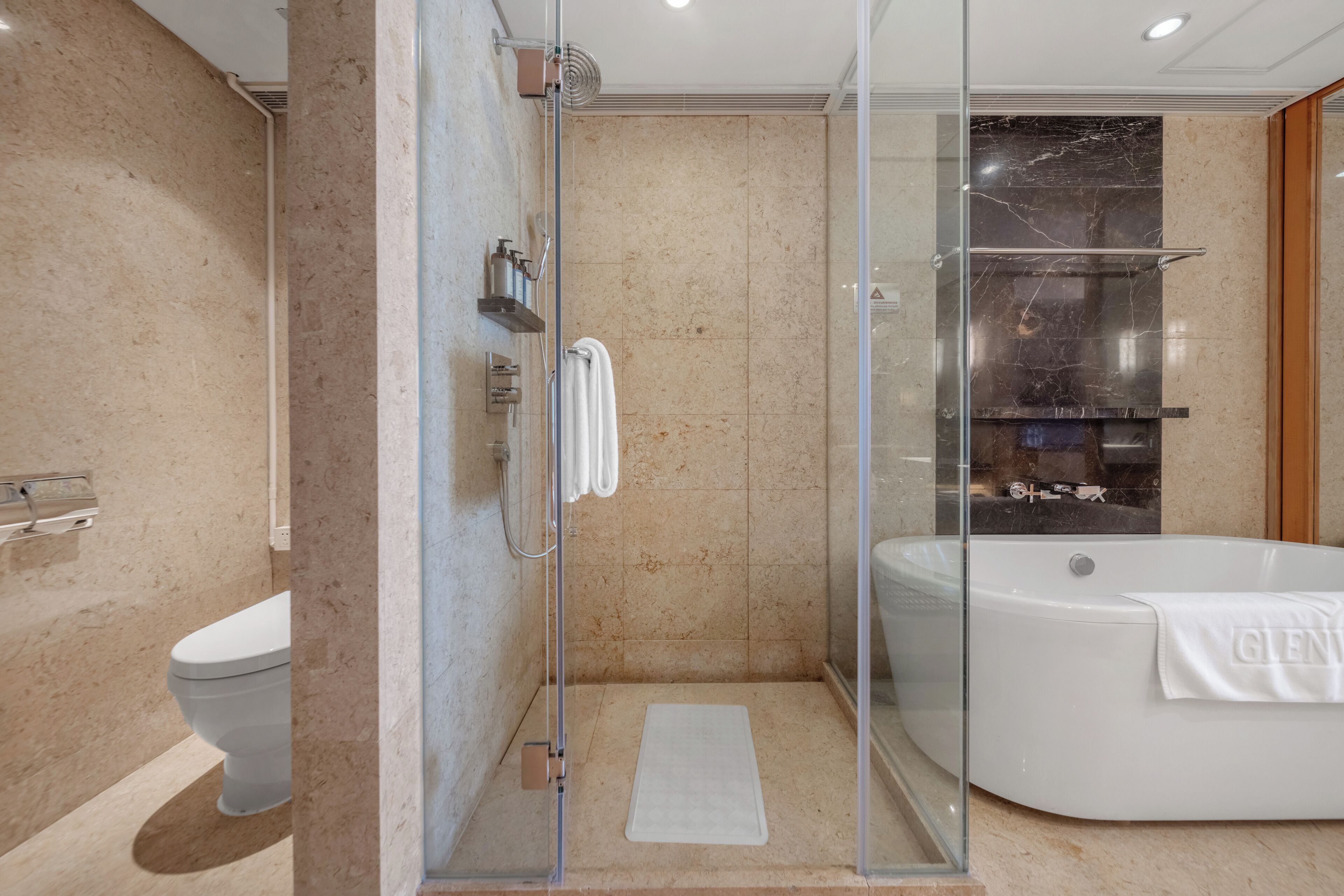 Une salle de bain moderne avec une douche à parois de verre, une baignoire sur pieds et des toilettes.