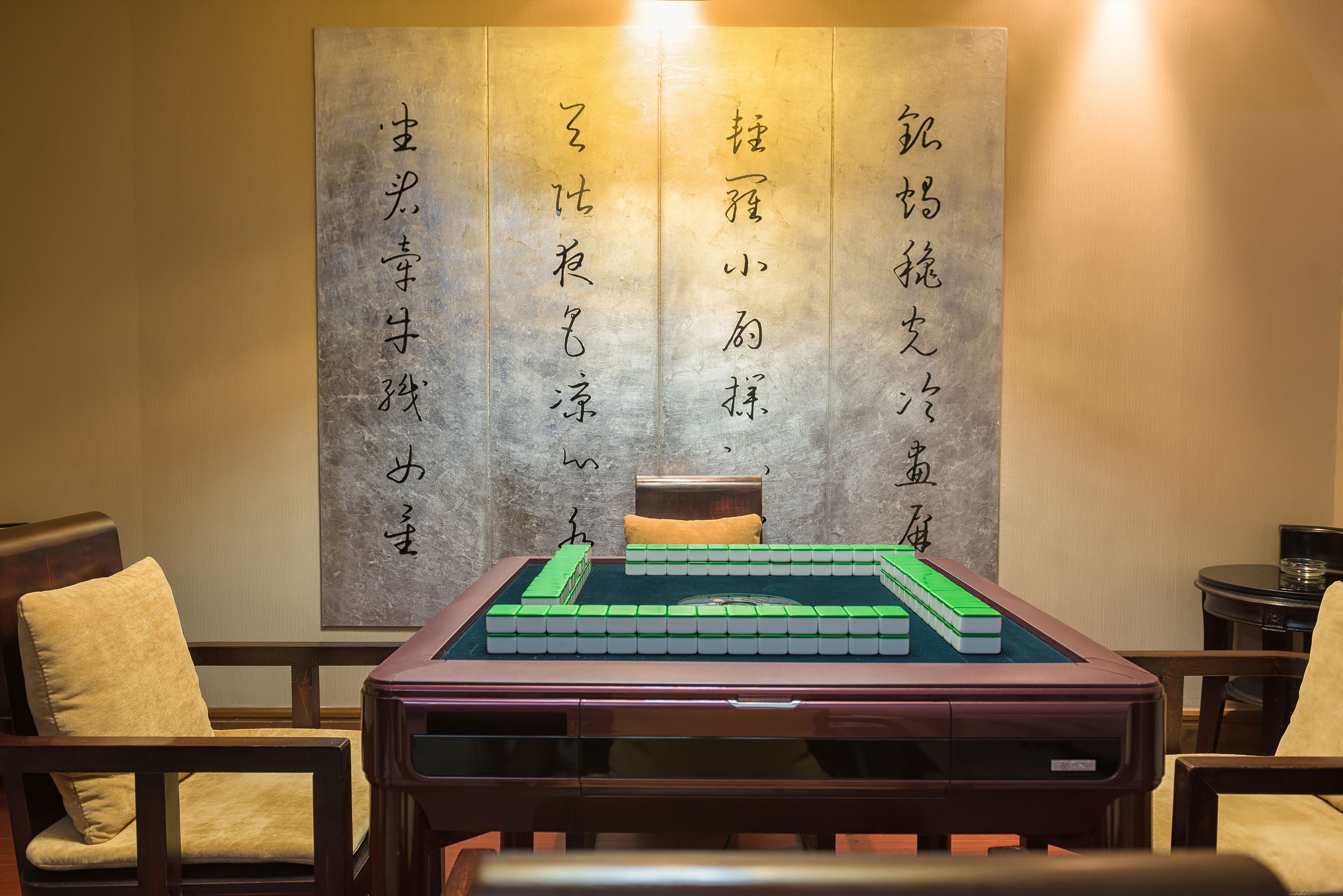 A room with a tatami mat, a low wooden table, and a bed with a yellow pillow.