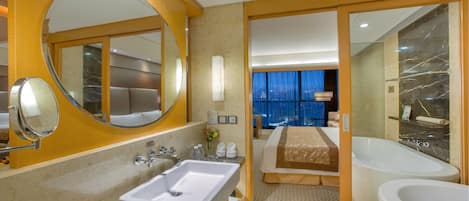 Un baño de hotel moderno con un lavamanos grande, un espejo y dos bañeras separadas.