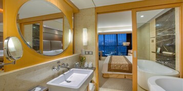 Un baño de hotel moderno con un lavamanos grande, un espejo y dos bañeras separadas.