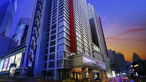 A high-rise building with a prominent red vertical feature, multiple floors, and a modern architectural design.