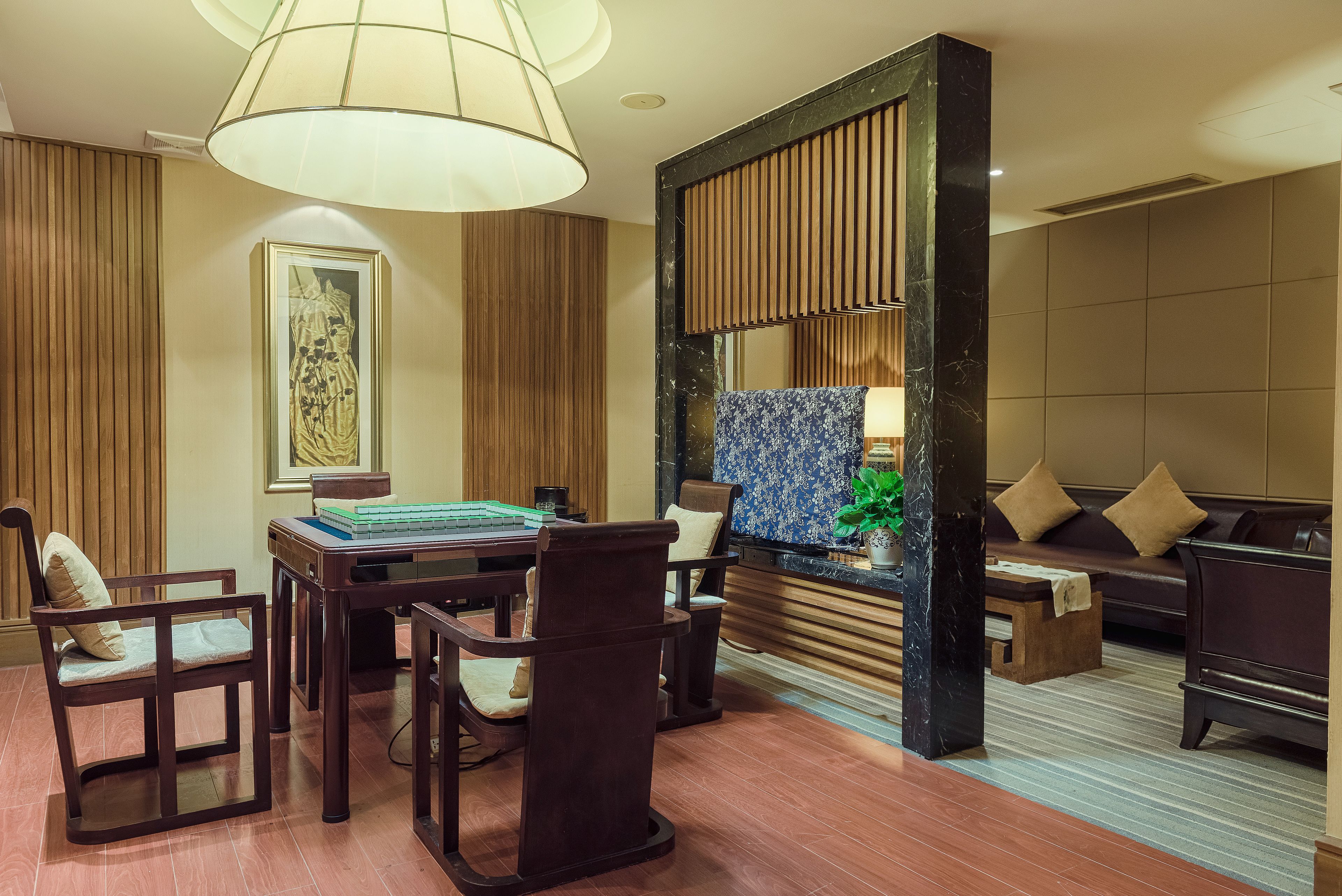 Een moderne hotellobby met een eetgedeelte, een bank en een decoratieve wand.