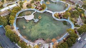 An aerial view of a park with multiple ponds, pathways, and surrounding greenery. - Crowne Plaza Wuxi City Center by IHG (Wuxi)