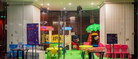Zona infantil con estructuras de juego coloridas y asientos.