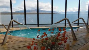 Eine Holzterrasse mit Pool und Blumenarrangement.
