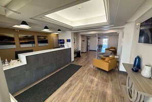 A reception area with a counter, seating, and artwork on the walls. - Days Inn by Wyndham Stony Plain (Stony Plain)