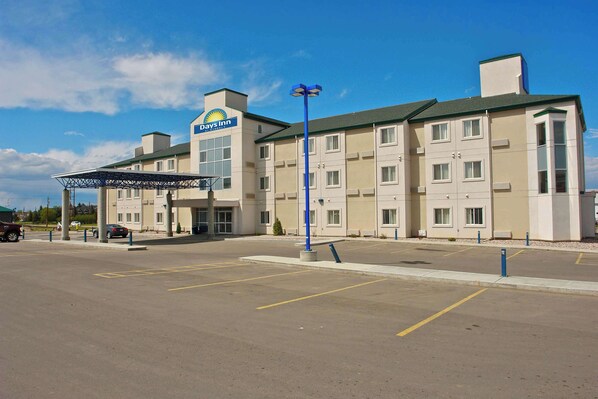 A Days Inn hotel with a parking lot and a covered entrance. - Days Inn by Wyndham Stony Plain (Stony Plain)