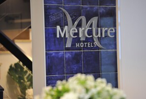 A sign for Mercure Hotels with a modern design and a blue background. - Mercure Paris Saint Cloud Hippodrome (Saint-Cloud)