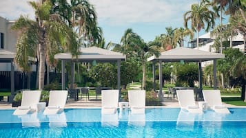 Una piscina al aire libre, camas de piscina gratis, sombrillas