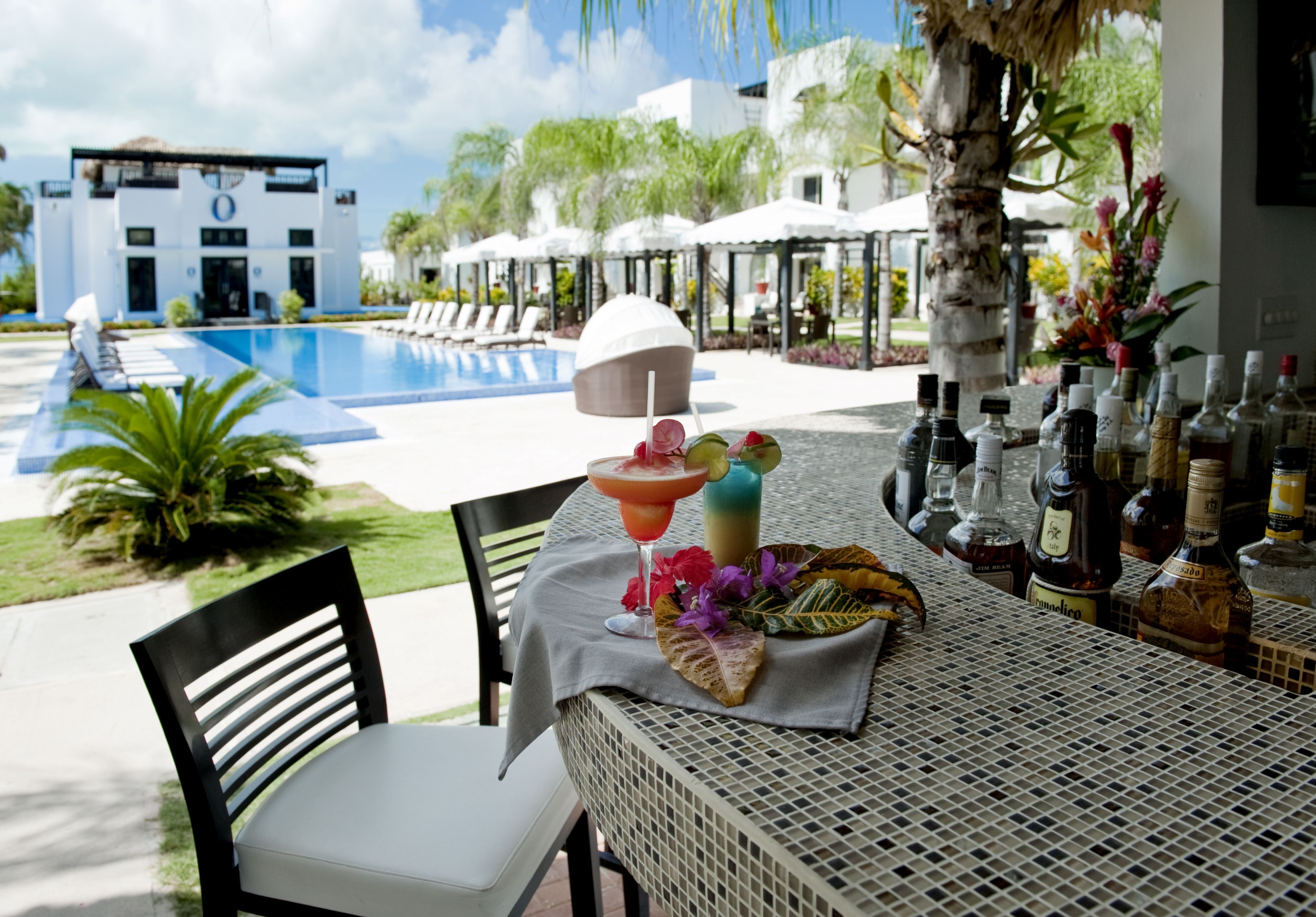 A poolside bar with a view of a pool and a building in the background.