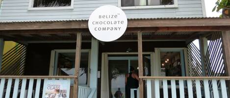 A two-story building with a porch and a sign for Belize Chocolate Company.