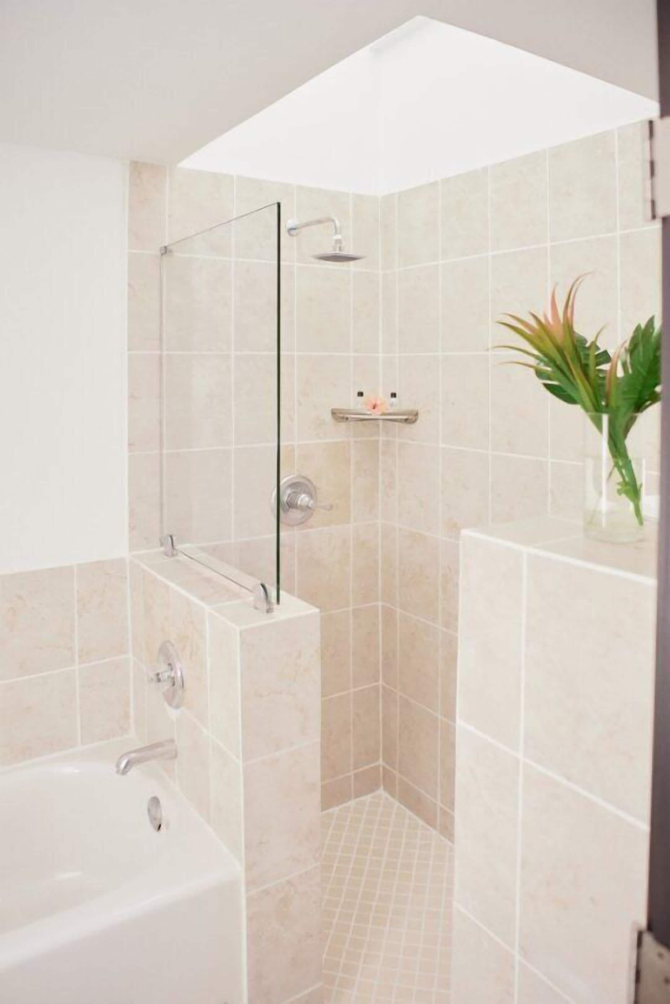Une salle de bain moderne avec une douche à parois de verre, une baignoire et une étagère contenant des articles de toilette.