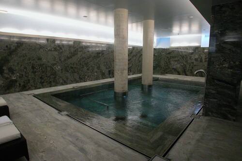Una piscina cubierta, tumbonas