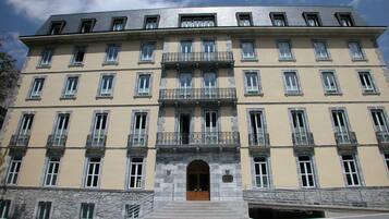 Un edificio de varios pisos con fachada simétrica, amplias ventanas y una entrada central con escalinata.