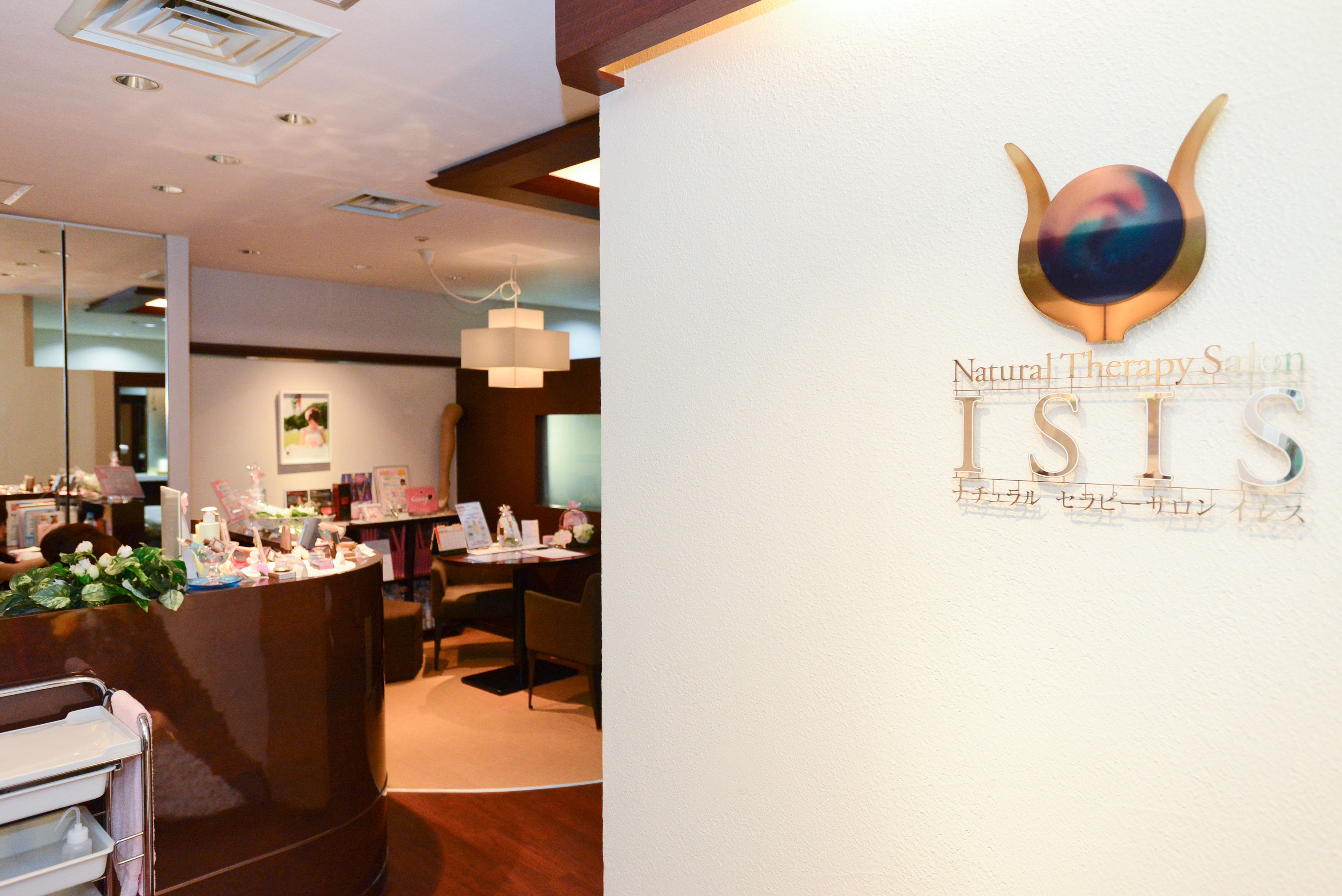 A reception area with a counter, chairs, and a wall-mounted logo for Natural Therapy Salon.