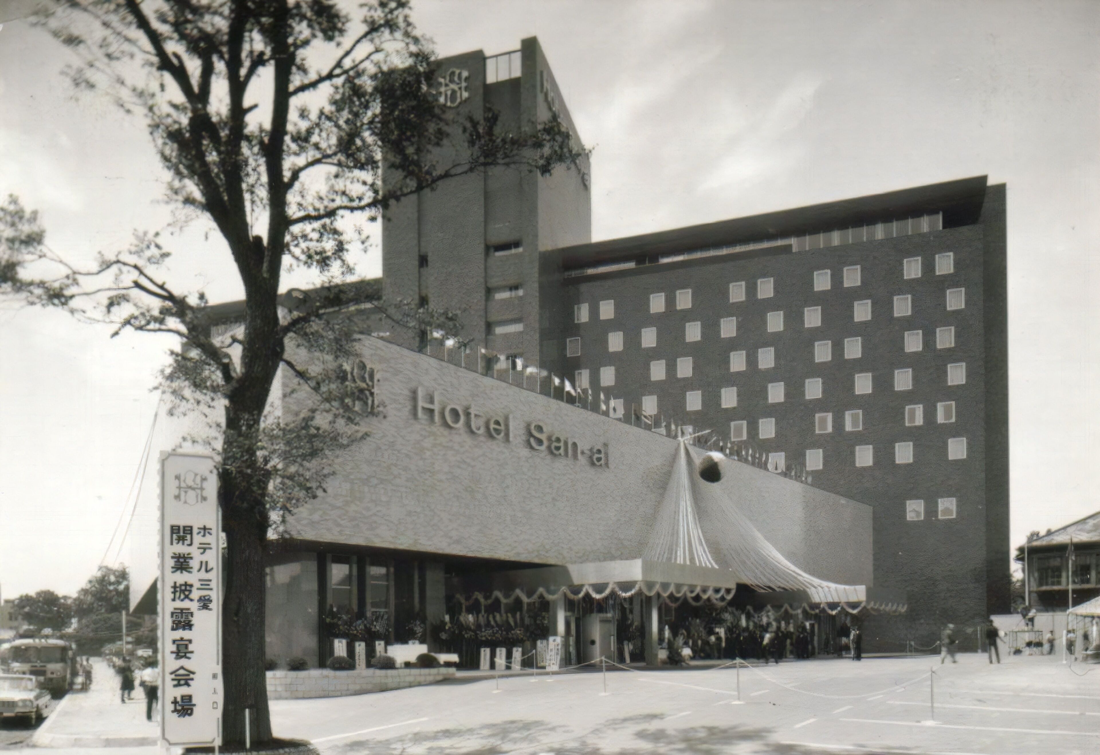 A hotel with a large sign, multiple floors, and a prominent entrance.