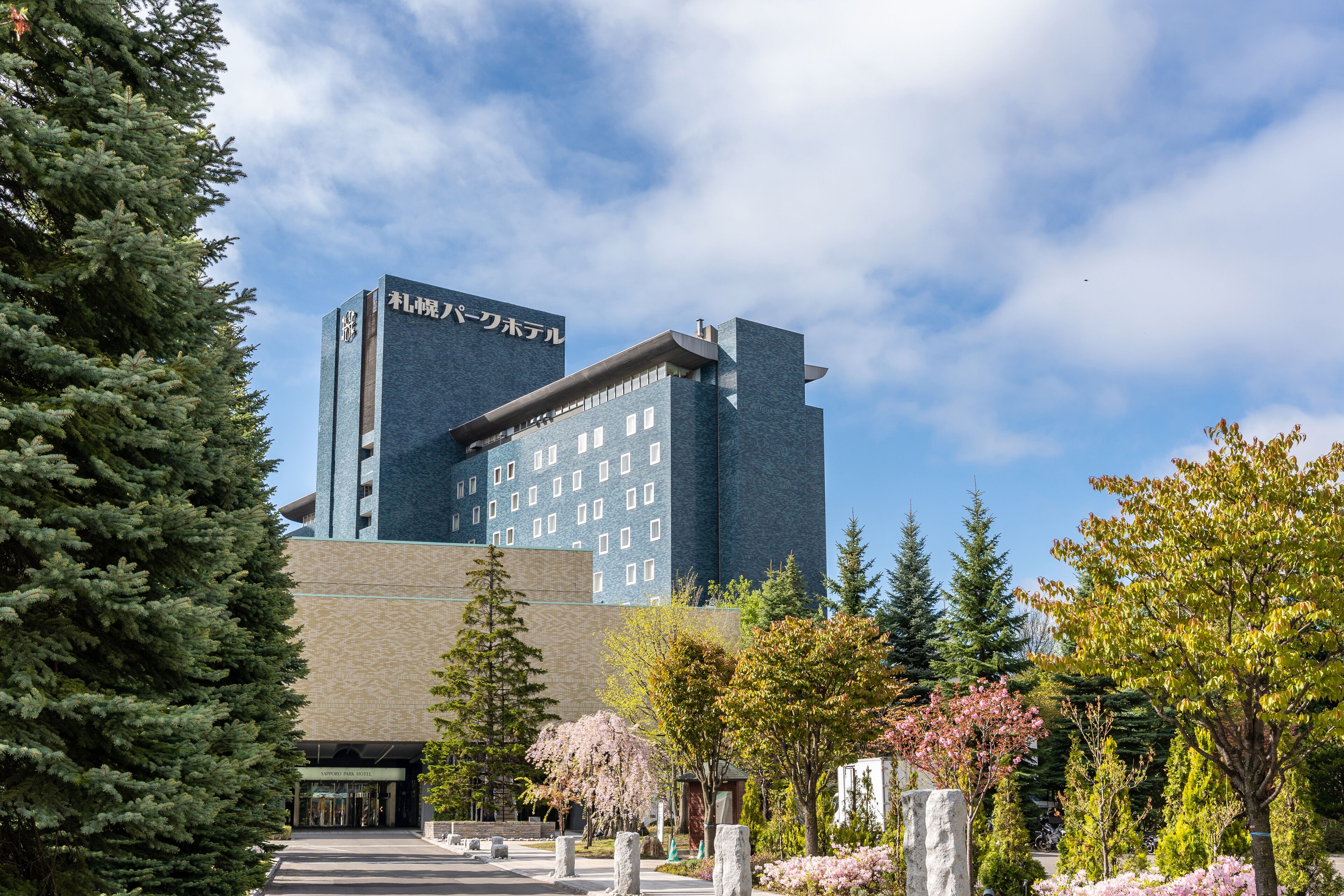A modern building with a prominent entrance and a sign in a foreign language.