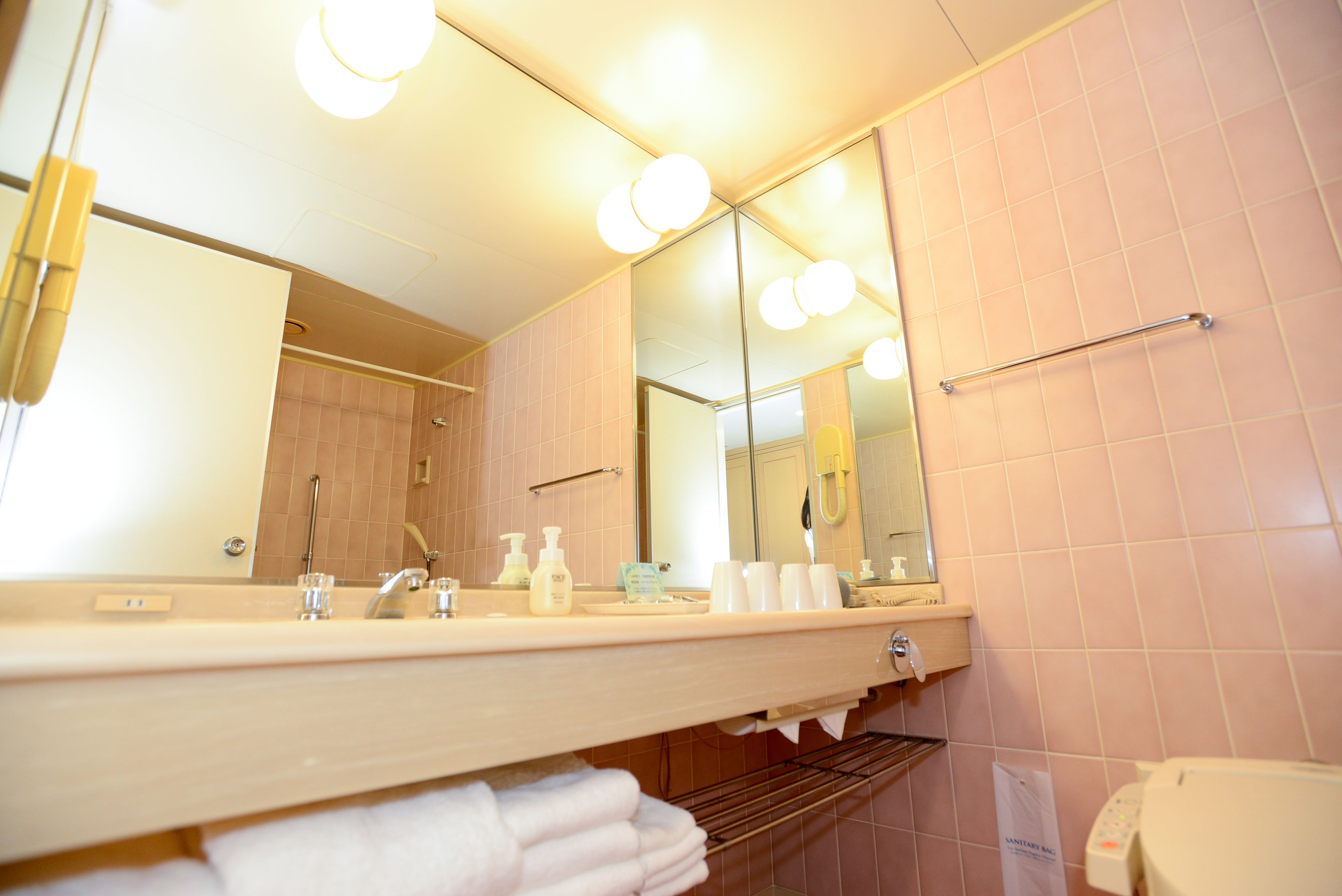 Un bagno con lavandino, specchio e portasciugamani.