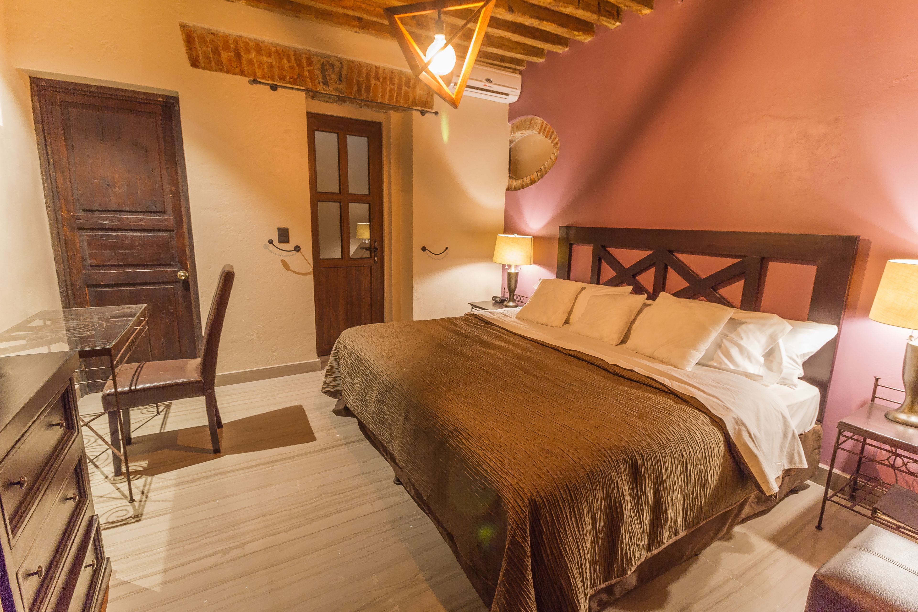 A bedroom with a wooden bed, a desk, and a chair.
