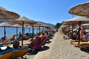 Sur la plage, chaise longue, parasol, serviettes de plage