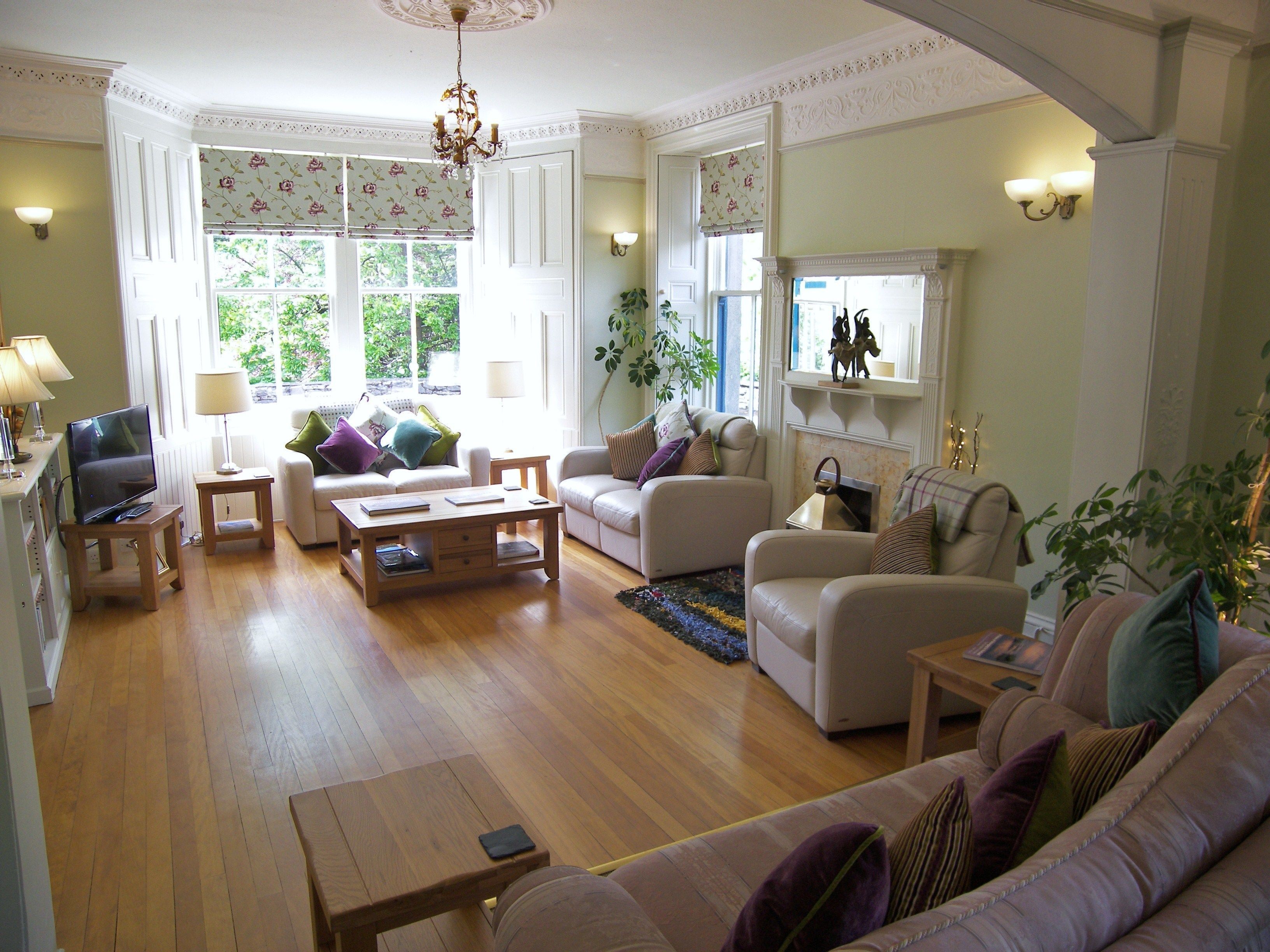 A spacious living room with a fireplace, comfortable seating, and a television.