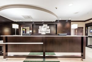 Un mostrador de recepción con un letrero que dice 'Holiday Inn' y una cámara de seguridad en el techo.