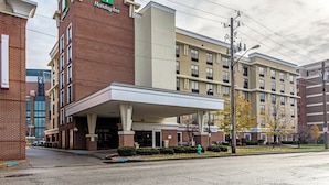 A Holiday Inn hotel with a brick facade, a covered entrance, and a parking lot. - Holiday Inn Indianapolis Downtown by IHG (Indianapolis)