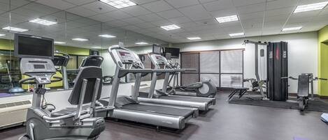 A gym with treadmills, elliptical machines, and weight equipment.