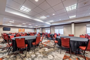 A conference room with multiple tables and chairs, a patterned carpet, and ceiling lights. - Holiday Inn Indianapolis Downtown by IHG (Indianapolis)