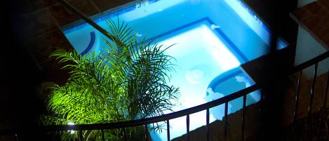 Una piscina con vista despejada al agua, rodeada por una barandilla y plantas en macetas.