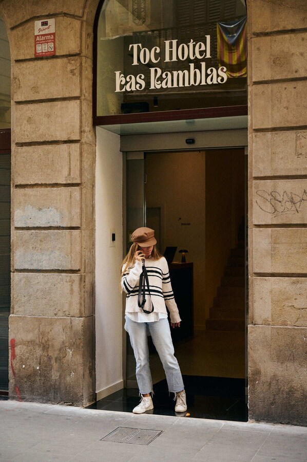 The entrance to Toc Hotel Las Ramblas with a stone facade and a sign above the door. - TOC Ramblas (Barcelona)