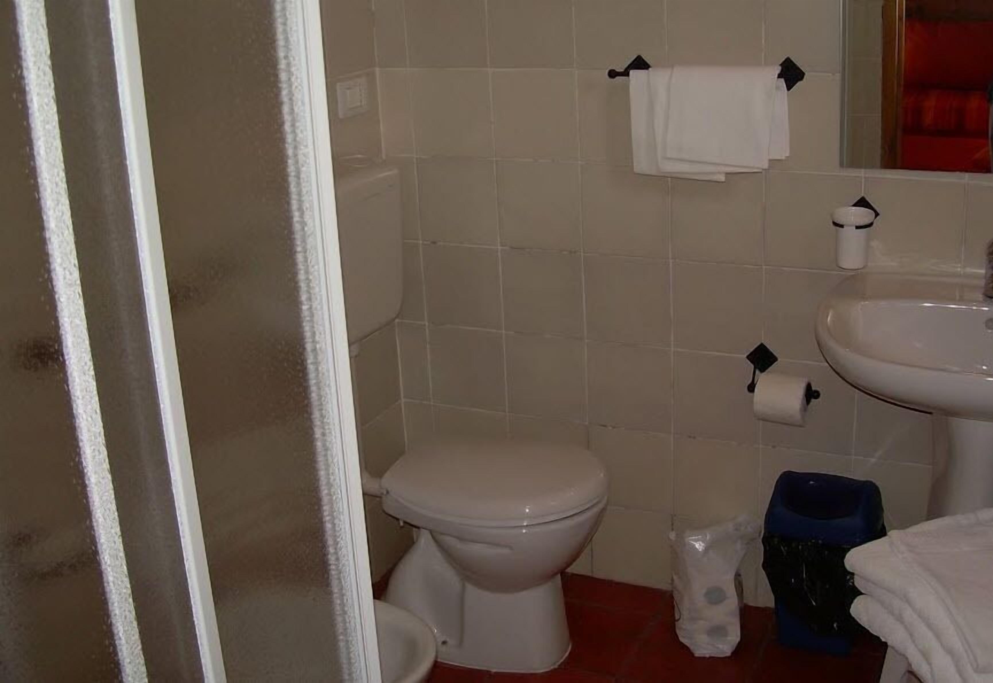 Ein Badezimmer mit Toilette, Waschbecken und Spiegel.