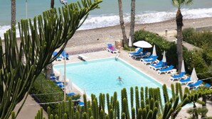 A pool area with palm trees and a view of the ocean. - Hotel Za' Maria (Caronia)