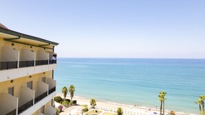 A multi-story hotel with balconies overlooking a beach and the sea. - Hotel Za' Maria (Caronia)