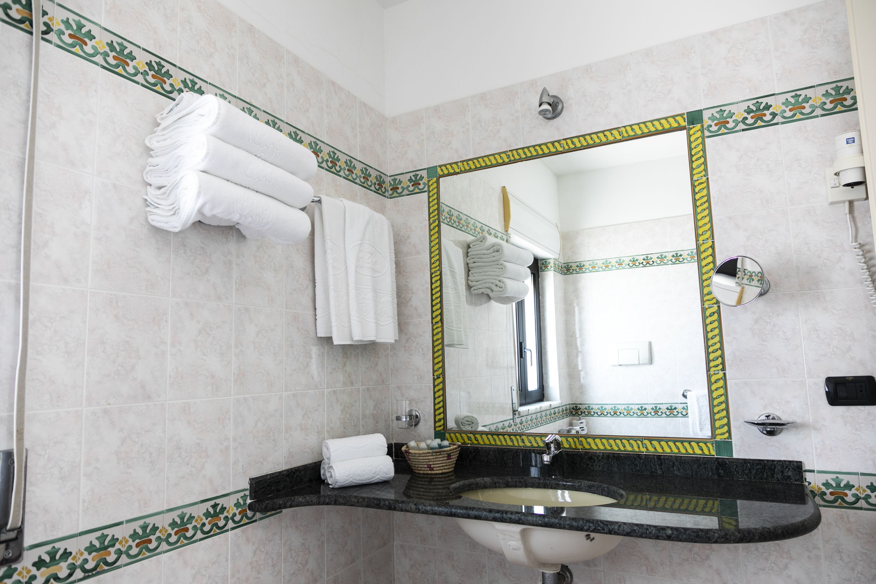 A bathroom with a sink, mirror, and towel rack.