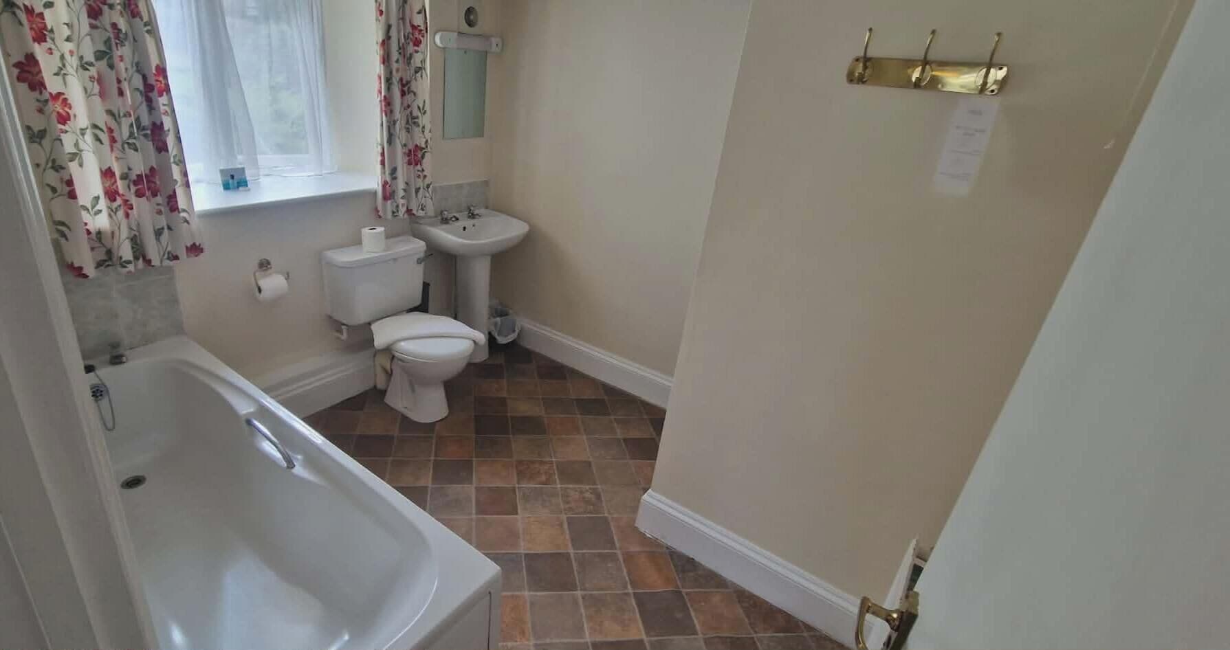 A bathroom with a bathtub, toilet, and sink.
