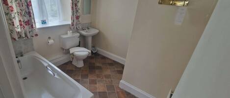 A bathroom with a bathtub, toilet, and sink.
