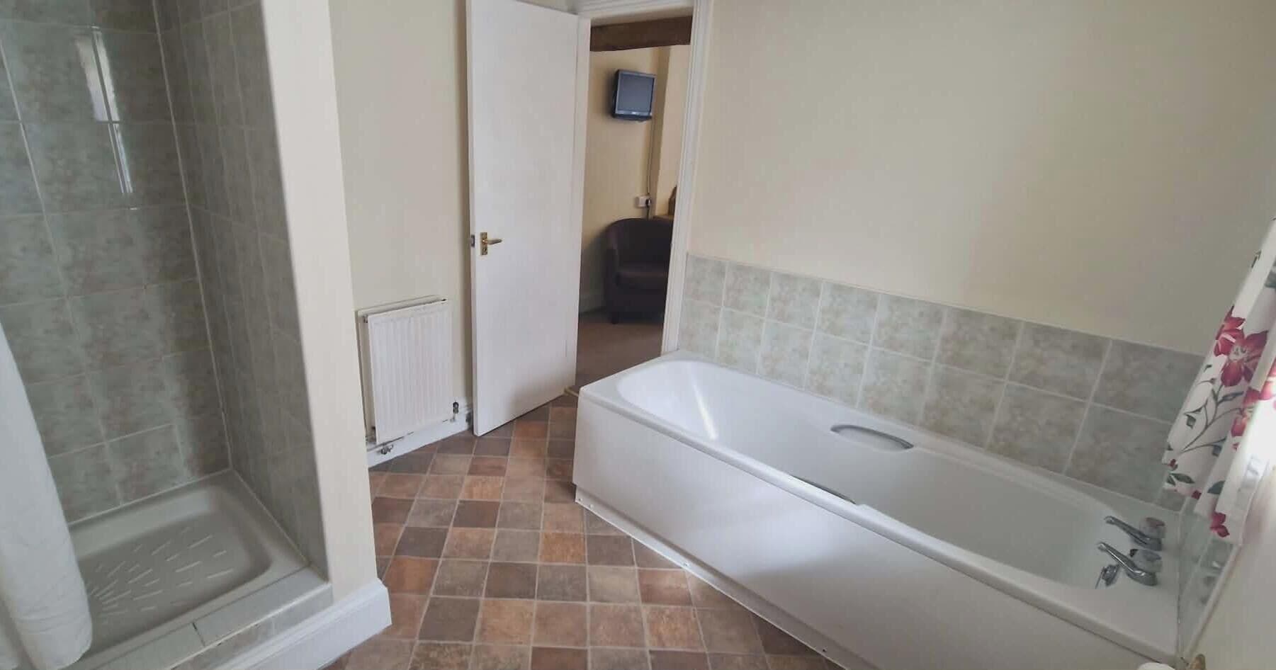 A bathroom with a bathtub, a shower, and a toilet.