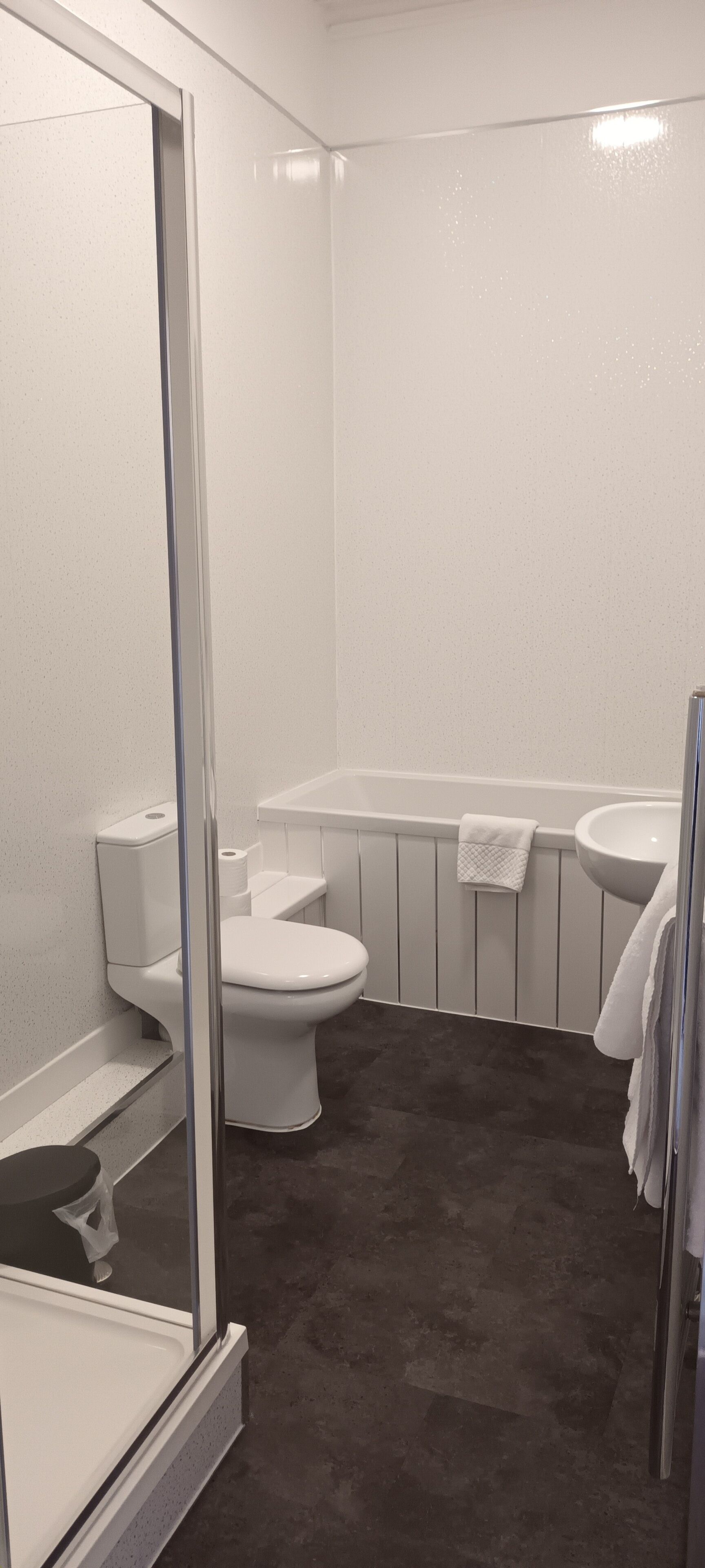 A bathroom with a toilet, sink, and bathtub.
